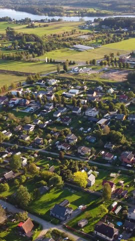 Beautiful vertical shot of green suburban neighborhood, epic area to live with lots of green garden, aerial, dolly shot backwards