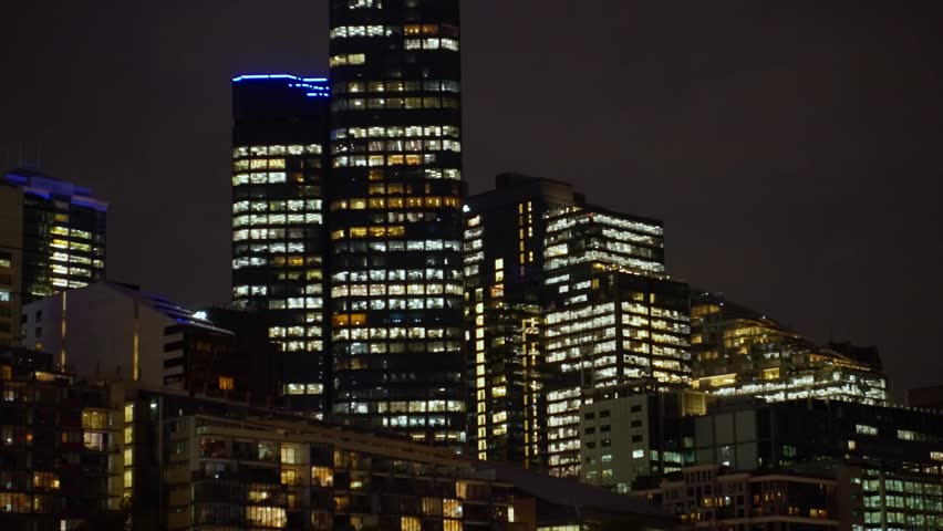 Buildings and towers with offices and apartments at night in Melbourne Australia. Vibrant night life in famous city. Downtown district with residential and company offices. Financial hub
