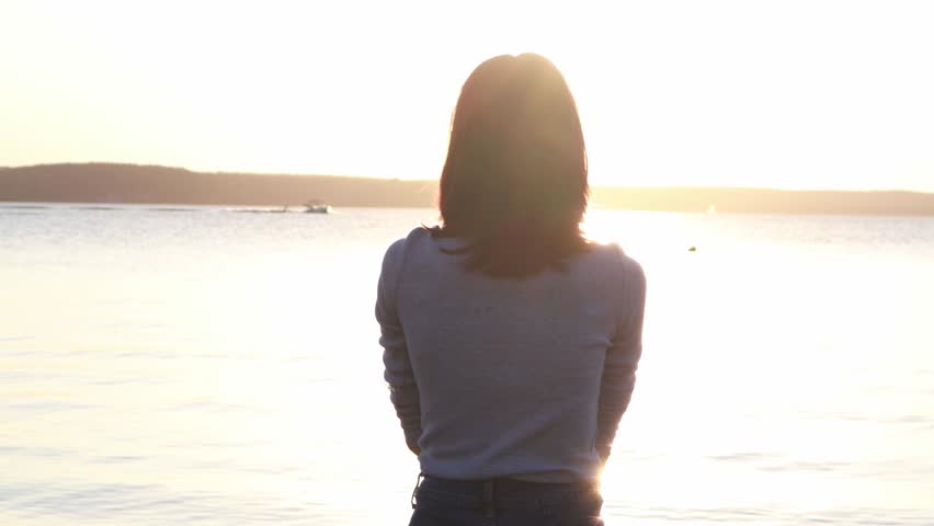 Hand of happy girl at sunset. Sunset between the hands of girl. Happy girl with long hair dreamily stretches out her hand to the sun. Child