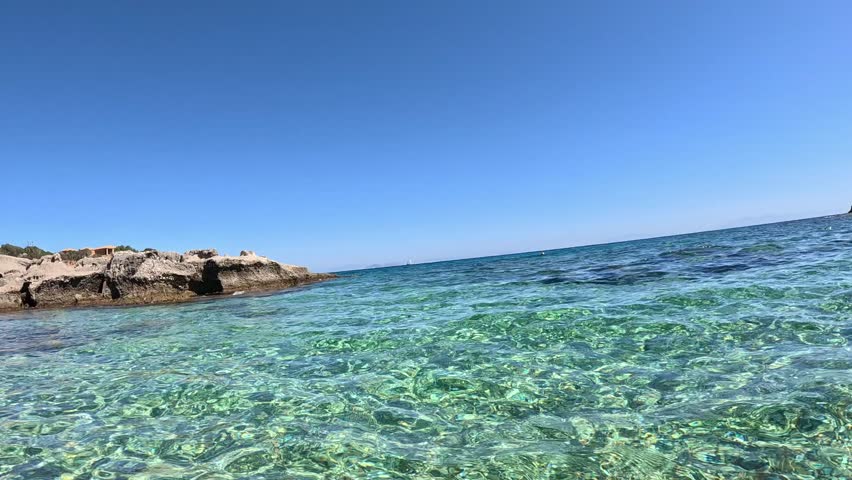 Diving and swimming in the clear waters of the Mediterranean Sea. Man paddling with his hands underwater. POV underwater shot, split level, slow motion