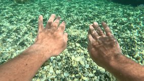 Diving and swimming in the clear waters of the Mediterranean Sea. Man paddling with his hands underwater. POV underwater shot, split level, slow motion - Powered by Shutterstock - Get 15% off with code: PIKWIZARD15