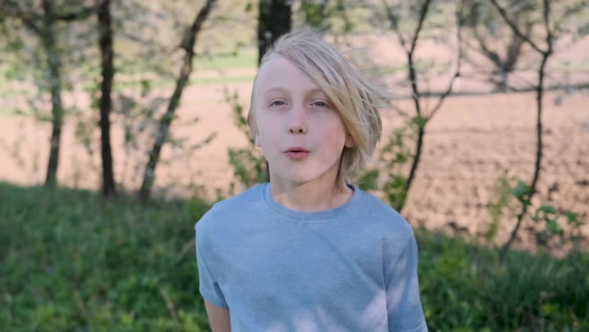 Young boy reacting with surprise and shock, holding his head in his hands, captures a moment of realization in slow motion