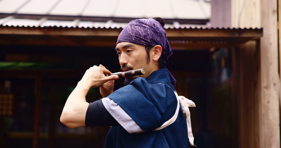 Japanese man, shakuhachi and playing for music, culture and zen with meditation, Buddhist and sound. Asian person, bamboo and instrument for tradition, performance and spiritual heritage with flute