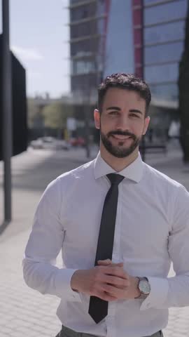 Vertical. Attractive young adult confident muslim business man posing smiling outside office building. Formal professional male standing arms crossed positive attitude looking happy at camera outdoors