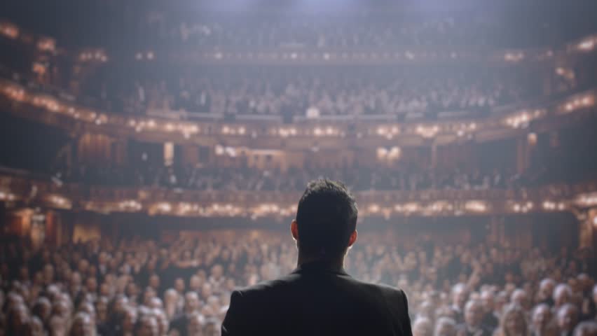 Silhouette Public Speaker On Stage Addressing Large Arena Audience Success Inspiration Leadership