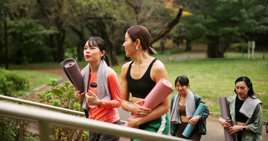 People, friends and walking with mat from yoga outdoor, fitness and journey for mindfulness peace. Japanese, women and water bottle for pilates adventure, holistic healing and wellness pride in Japan