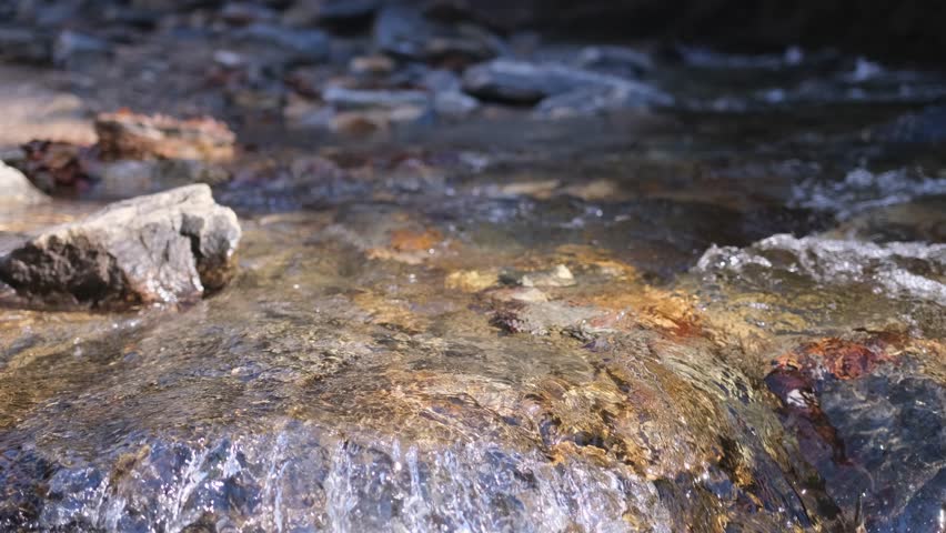 Experience natures beauty as a stream flows over rocks in a forest