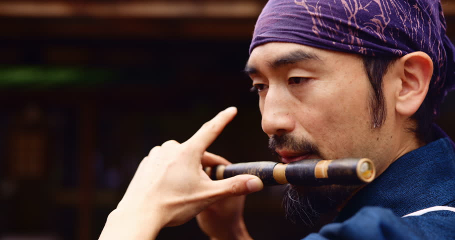 Japanese man, flute and playing for culture, music and zen with meditation, Buddhist and sound. Asian person, bamboo and instrument for tradition, performance and spiritual heritage with shakuhachi
