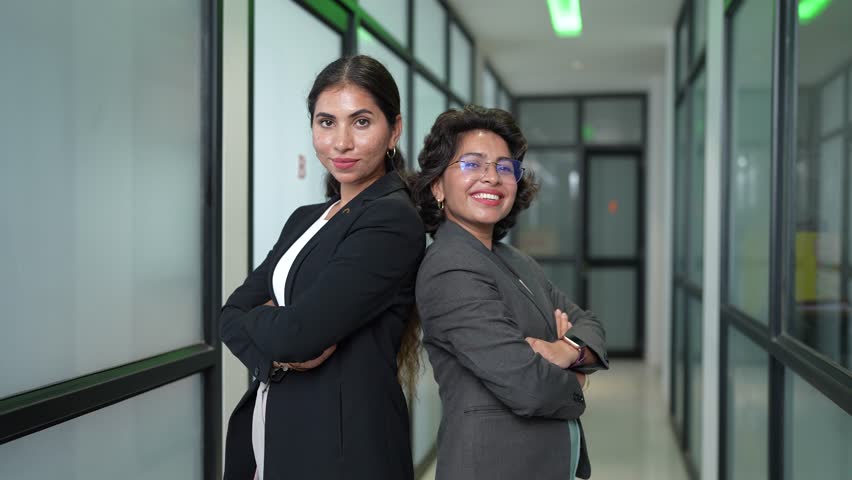 Portrait of Confident successful young indian businesswomen standing arms crossed in office looking at camera. Women power partnership.
