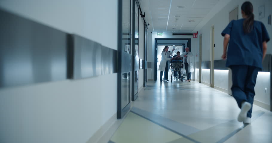 Diverse Female and Male Emergency First Responders Move a Stretcher Through the Hospital Hallway. Paramedics and Doctors Urgently Transporting a Critical Injured Patient to the Operating Room