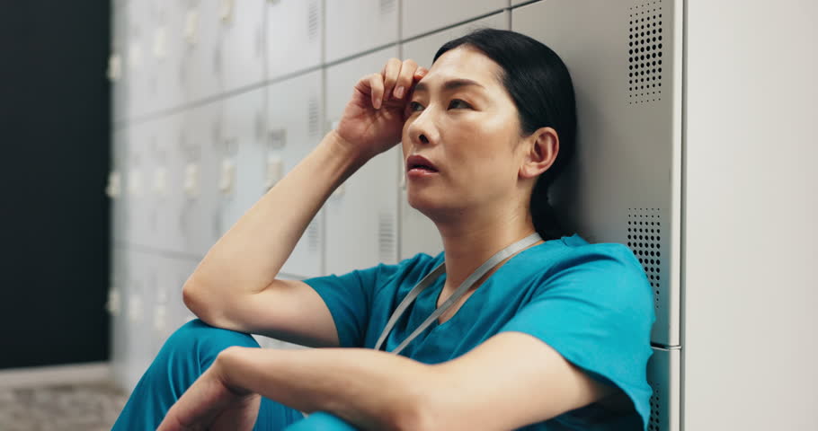 Japanese woman, nurse and headache in doubt, burnout or mistake at hospital locker. Frustrated, sad physician or medical healthcare person in stress, loss or failed surgery in clinic break room