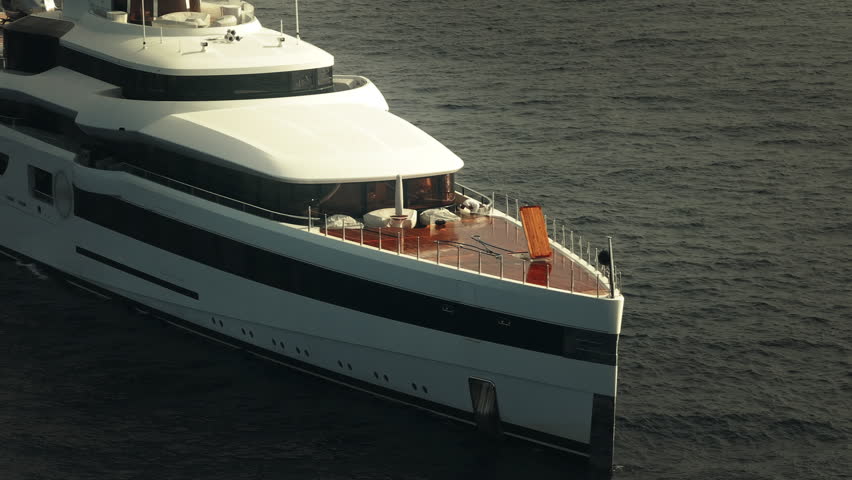 Aerial view of a luxury billionaire megayacht with a helicopter sitting on the helipad in the coast of Sardinia, Italy