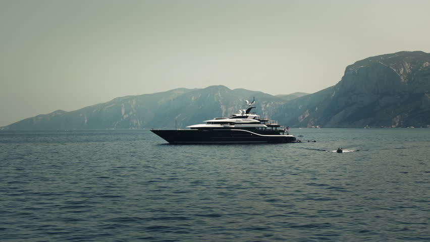 Luxury mega yachts in the mountainous coast of Sardinia, aerial view during summer