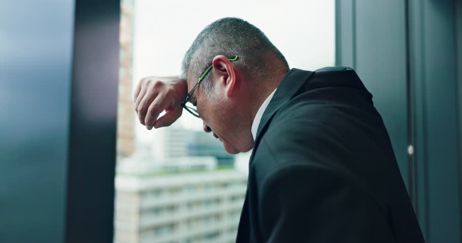 Mature businessman, depression and thinking by window with lost investment, bankrupt and stress at agency. Person, back and anxiety for economy, mental health and worry at trading company in Japan