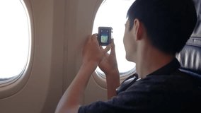 Boy Captures View From Airplane Window With Portable Camera While Traveling in Sky. Young boy excitedly films expansive view outside plane window using portable action camera during flight, enjoying - Powered by Shutterstock - Get 15% off with code: PIKWIZARD15