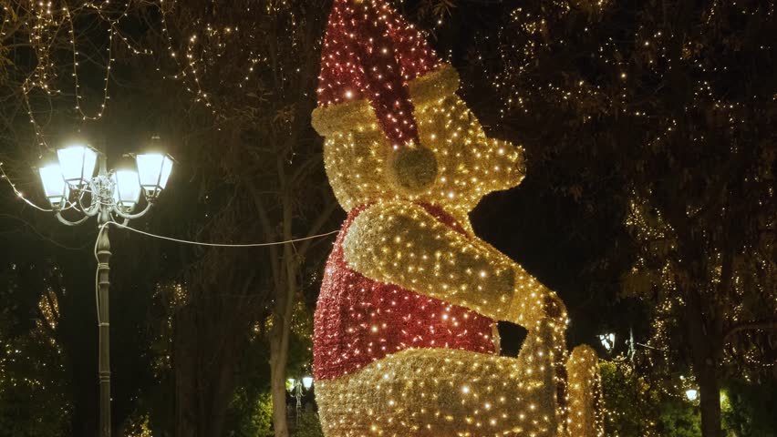 Christmas teddy bear at night in decorated and illuminated central square Syntagma in Athens, Greece. Winter holidays background