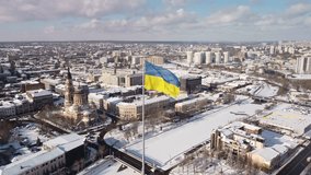 Ukrainian flag proudly waving over the snowy cityscape of Kharkiv, captured from a drone's aerial perspective, showcasing a blend of historic architecture and modern skyline on a bright winter day - Powered by Shutterstock - Get 15% off with code: PIKWIZARD15