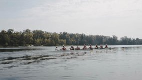 Rowing team training. Side view of 8 young caucasian male rowers, during a rowing practice, athlete sitting in a boat in the river Dnipro, rows through a calm water in autumn. 4k footage. City area in - Powered by Shutterstock - Get 15% off with code: PIKWIZARD15
