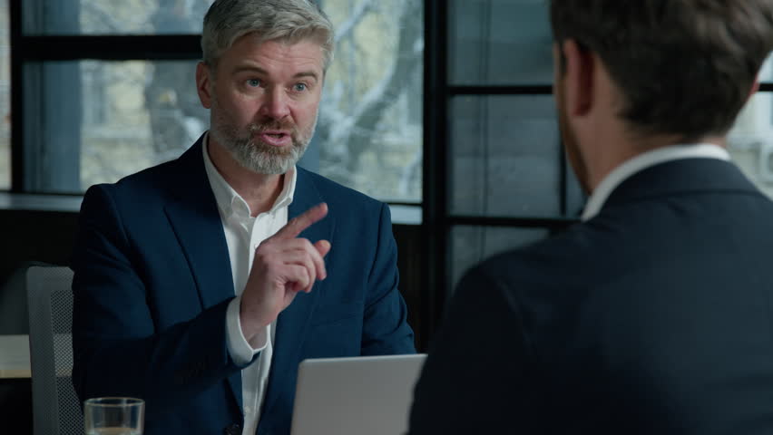 Serious Caucasian man consultant businessman consulting client business job interview in office employer hr manager communicate with male employee candidate men businessmen discuss project at meeting