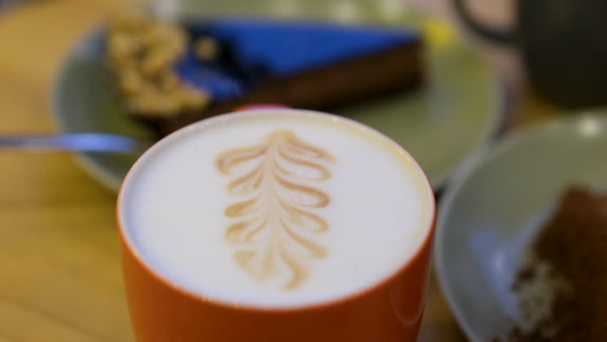 Apple Crabble orange cup with delicious latte crab apple drawing on white foam chocolate cake in the background - Powered by Shutterstock - Get 15% off with code: PIKWIZARD15