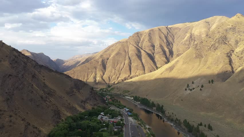Aerial drone shot of Salmon river and town of Riggins Idaho through high mountains.