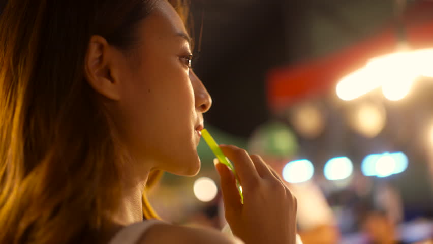 Back view of happy asian woman in casual style walking and shopping at the street night market in the city, young female enjoy night travel street food urban lifestyle.