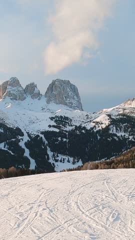 First-person view FPV first-person point of view POV of alpine skiing in Dolomites. Ski resort piste with people skiing in Dolomites in Italy. Ski area Belvedere. Canazei, Italy