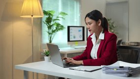 Asian businesswoman sitting in office looking at detailed graphs on laptop, PC computer, chart of real estate growth data, online financial documents in modern office. - Powered by Shutterstock - Get 15% off with code: PIKWIZARD15