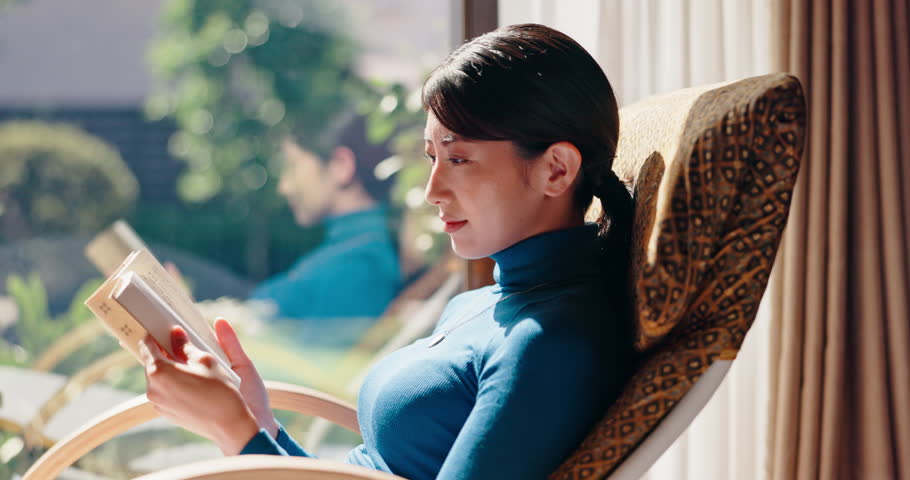 Chair, tea or Asian woman in home reading book for rest break or novel to relax in Japan. Chilling, comfortable or Japanese person drinking beverage with fiction story, or peace for fantasy or hobby