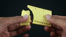 man's hand breaking a biscuits on black background - Powered by Shutterstock - Get 15% off with code: PIKWIZARD15