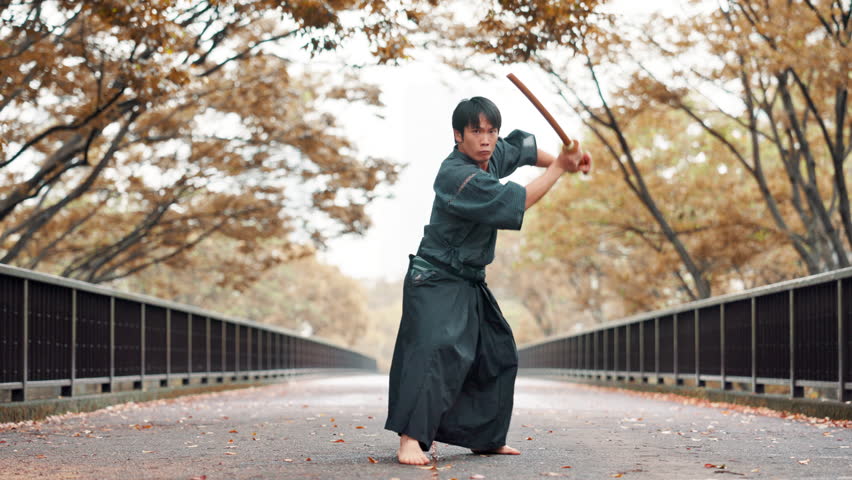 Aikido, bridge and sword with man in forest for martial arts exercise, practice or training. Bamboo, discipline and training with serious Japanese Samurai in nature for fight, kendo or self defense