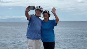 Happy senior couple of cyclists wearing helmets take a selfie with phone enjoying riding seaside with electric bicycles in a sunny day. Healthy lifestyle in retirement. Horizon over the sea - Powered by Shutterstock - Get 15% off with code: PIKWIZARD15