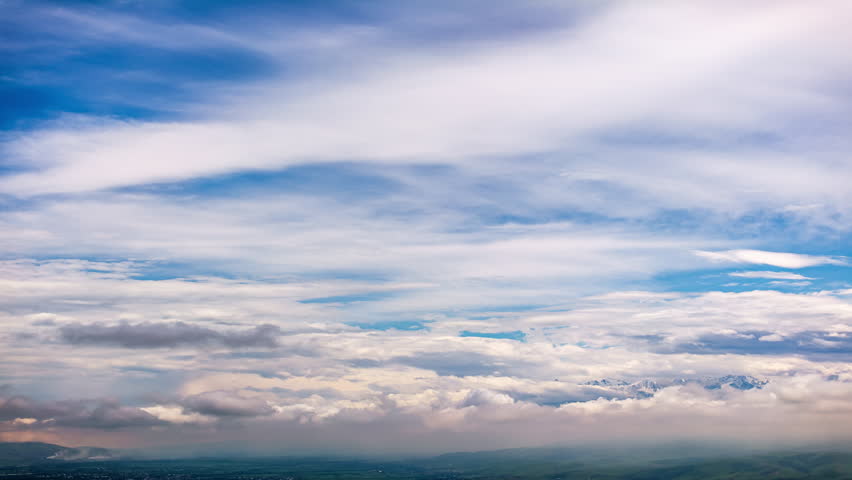 dense fluffy clouds floating over mountain range at summer day before storm, wide angle drone point of view hyperlapse