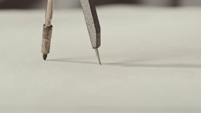 Close-up of compass drawing on white paper macro. Making some circle and measuring distance on white list by compass close-up. Drawing and sketching lessons concept. - Powered by Shutterstock - Get 15% off with code: PIKWIZARD15