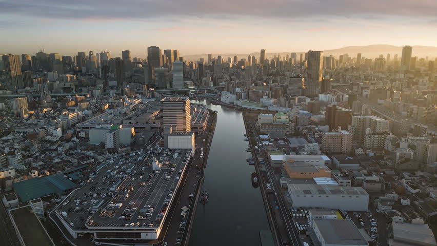 osaka city central skyline aerial view drone at sunrise flying over river to business district,modern high rise office buildings in the background - Powered by Shutterstock - Get 15% off with code: PIKWIZARD15