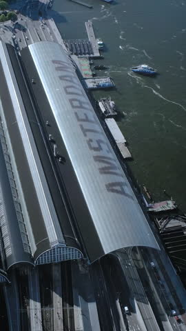Aerial view of the IJ and the Amsterdam Centraal Station in Netherlands. Many ferries and cargo ships.