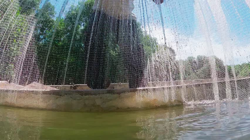 Slow motion video of a fisherman pulling a fishing net from a boat in a mangrove forest near the beach