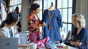Three female fashion designers meeting in design studio and discussing garment on mannequin - shot in slow motion - Powered by Shutterstock - Get 15% off with code: PIKWIZARD15