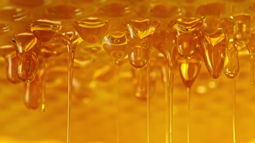 Super Slow Motion Shot of Golden Honey Dripping from Honeycomb at 1000fpt.