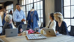 Male and female fashion designers meeting in design studio and discussing garment on mannequin - shot in slow motion - Powered by Shutterstock - Get 15% off with code: PIKWIZARD15