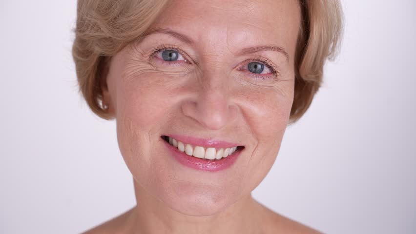 A joyful and cheerful middle-aged woman smiles warmly, radiating positivityband confidence. Self-love and graceful aging