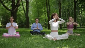 A yoga teacher in white leads a group meditation session in a serene park setting. Participants sit cross-legged, performing Chin Mudra with closed eyes, embodying mindfulness and inner peace. The - Powered by Shutterstock - Get 15% off with code: PIKWIZARD15