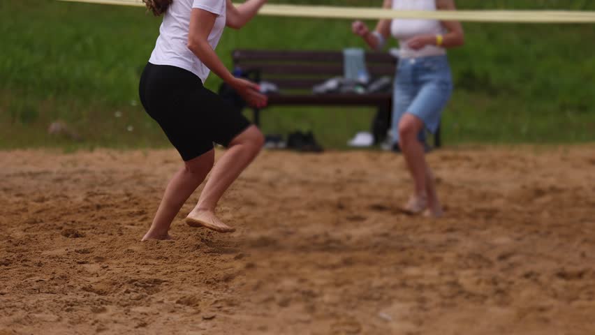 Volleyball game, junior teenage school team of kids play volleyball, players on the outdoor playground with net and green lawn grass court, sports children team during the game, summer sunny