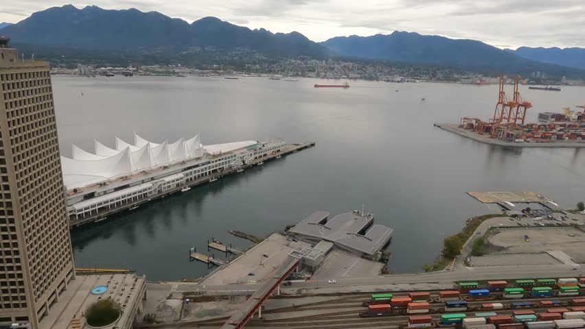 Timelapse, Vancouver in cloudy weather. Ship sails across the strait. Canada Place. View of the mountains. Port cranes. Part 2