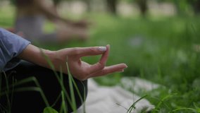 A close-up of a woman hand with light lavender nail polish in a meditative gesture, resting gracefully on her knee during yoga in a tranquil park. The elegant manicure adds a touch of refinement - Powered by Shutterstock - Get 15% off with code: PIKWIZARD15