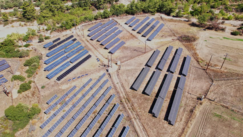 Rows of solar panels stretch across a rural landscape, capturing sunlight to generate renewable energy in a serene environment.