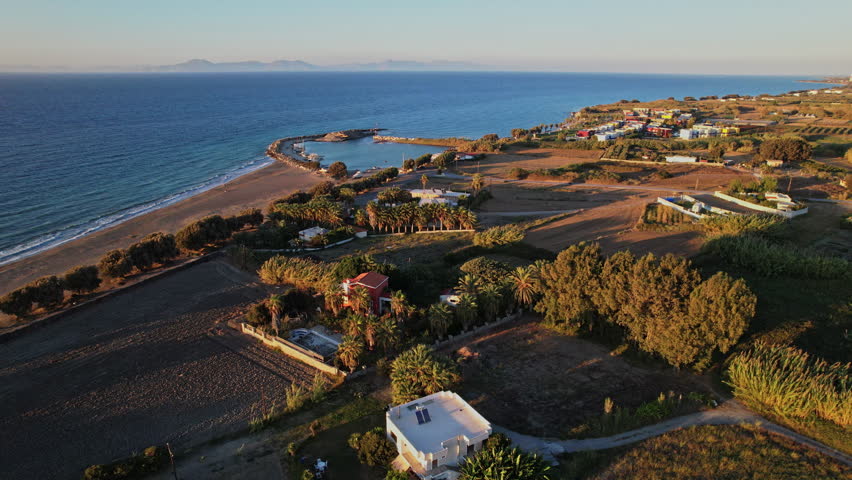 A serene coastal landscape features a blend of lush greenery, sandy beach, and gentle waves under a colorful sunset sky, showcasing natural beauty and tranquility.
