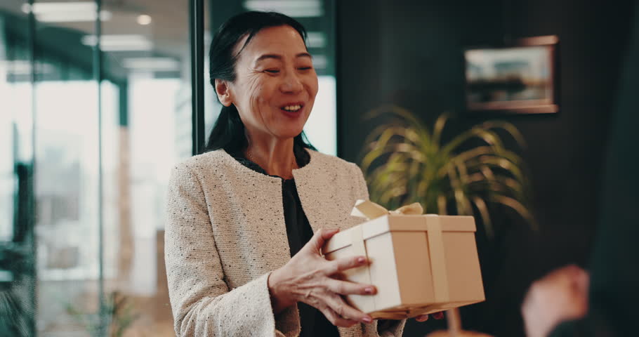 Gift, phone and surprise with Japanese business people in office for birthday, event or respect. Box, present and thank you with employee giving package to colleague for congratulations or milestone