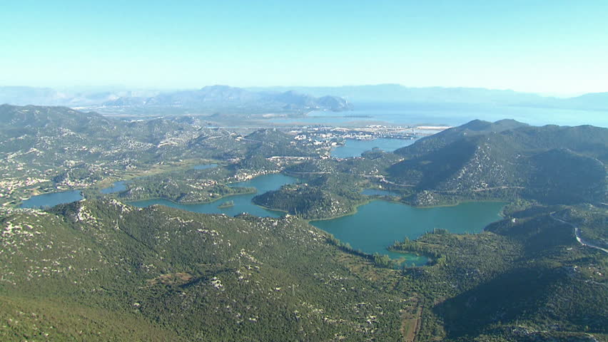 Aerial helicopter shot of The Bacina (Ba\xE6ina) lakes surrounded by green hills