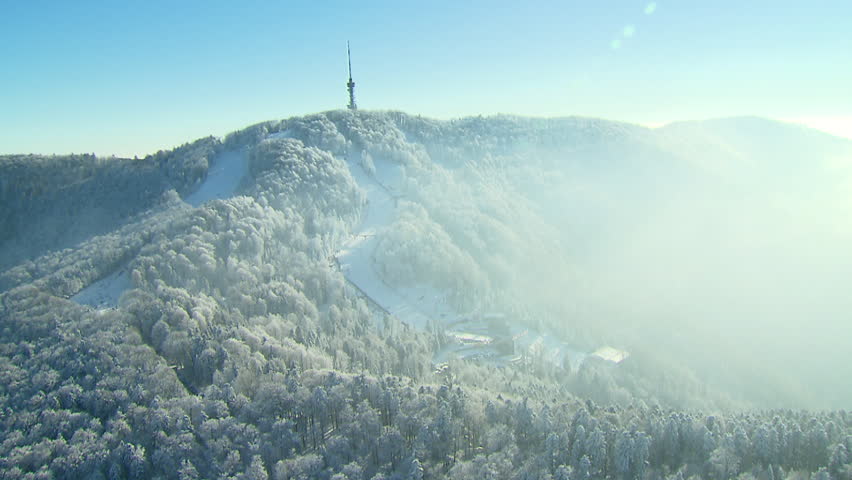 A ski track and TV tower on the top of the peak Sljeme, winter landscape. Aerial
